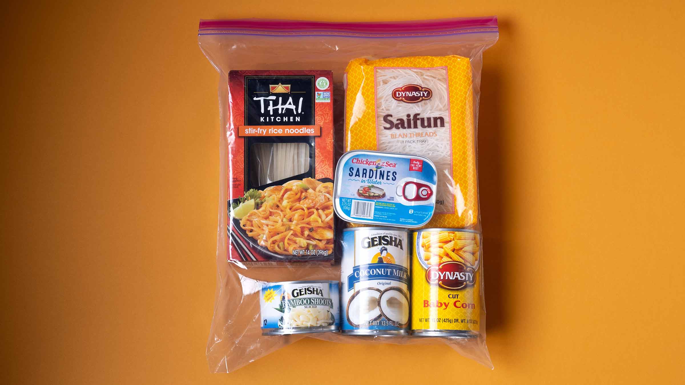 A Ziploc bag is filled with staple ingredients in the East Asian diet including rice noodles, baby corn, and coconut milk